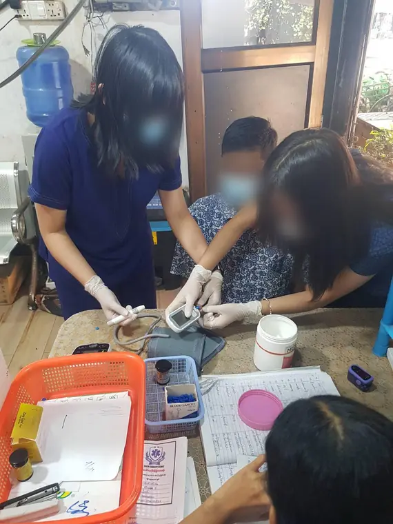 VAI student volunteers, blood glucose testing at a community clinic, Yangon
