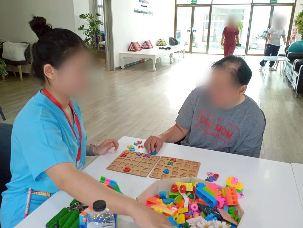 VAI student volunteers, memory and dexterity games with a resident, Bangkok